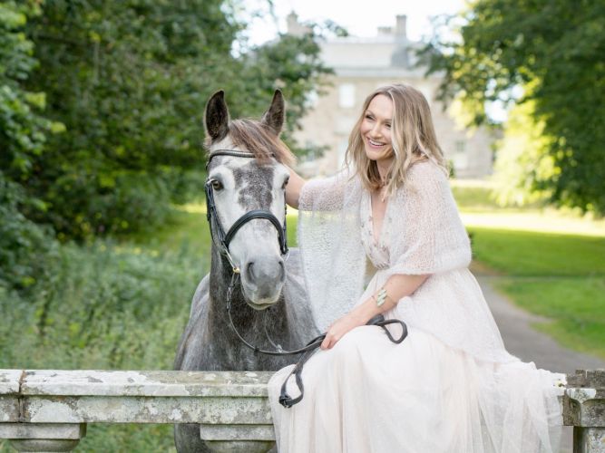 Woman in a pretty dress with her horse