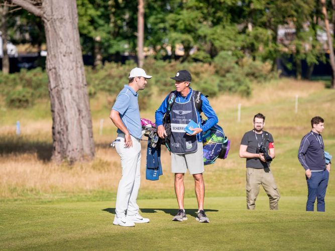 Scottie Scheffler in discussion with caddy