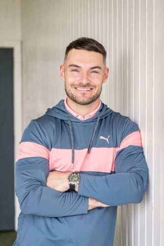 Golf teaching pro Fraser Clark leaning against a wall