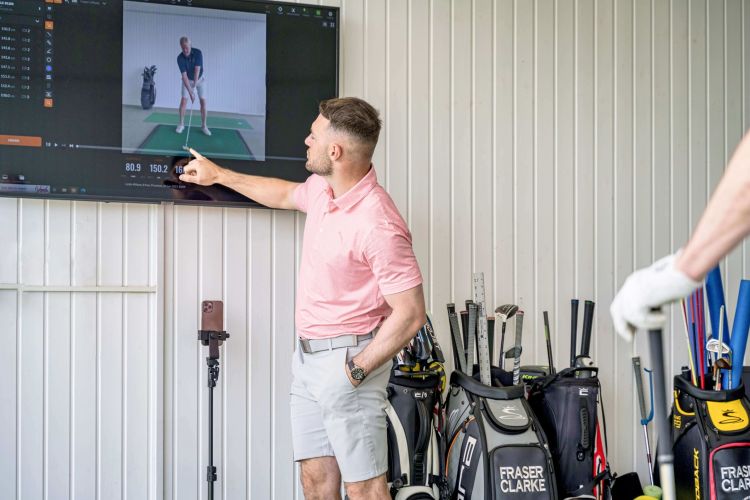 Golf teaching pro Fraser Clark explaining stats to a client