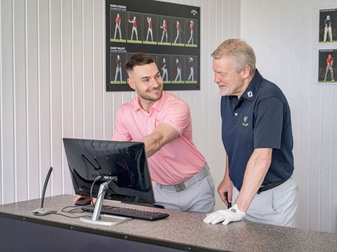 Golf teaching pro Fraser Clarke in conversation with student