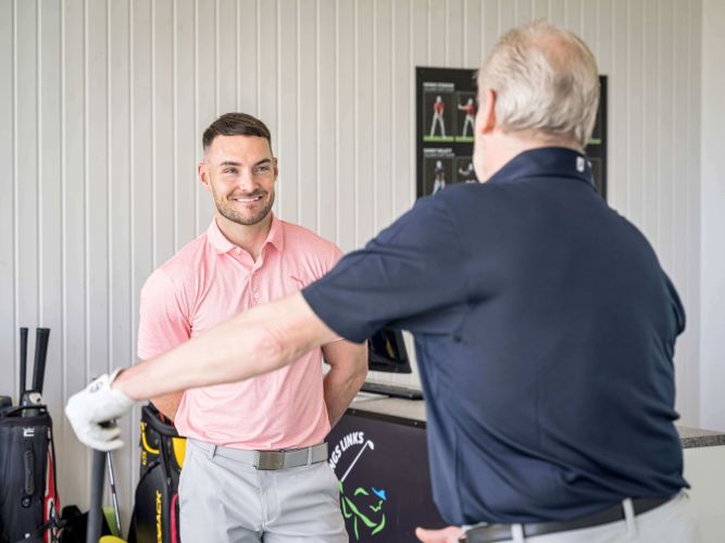 Golf teaching pro Fraser Clarke in conversation with student